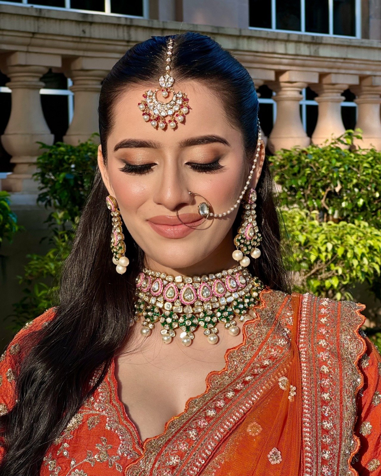 Bride in rust and emerald with reception makeup by Tejaswini in Mumbai