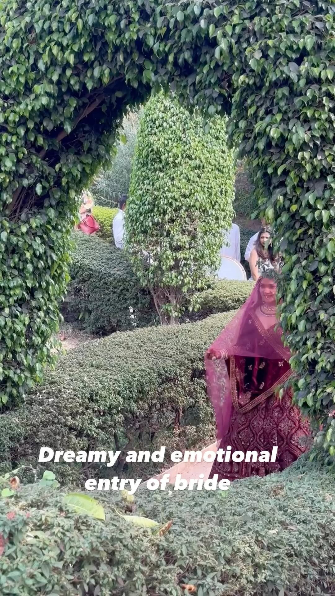 Still from the bridal entry reel filmed through the green garden archway at Fort JadhavGadh, Pune
