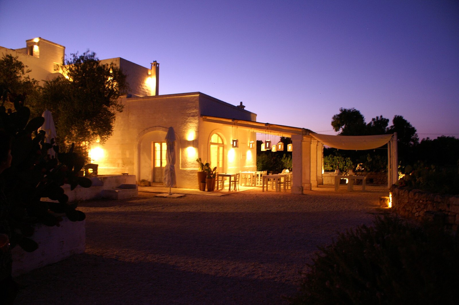 A masseria terrace lit for dinner near Savelletri